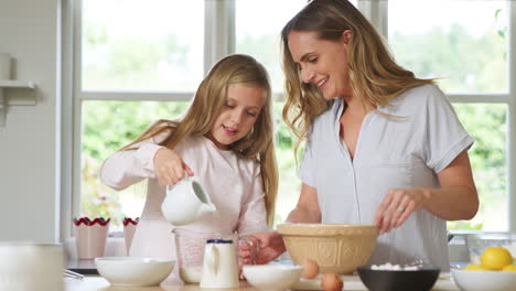 Madre-E-Hija-En-Pijama-Horneando-Y-Haciendo-Panqueques-Juntos-En-La-Cocina-De-Casa