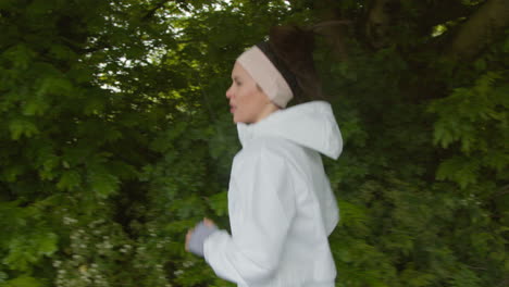 woman wearing headband exercising keeping fit running in countryside or park