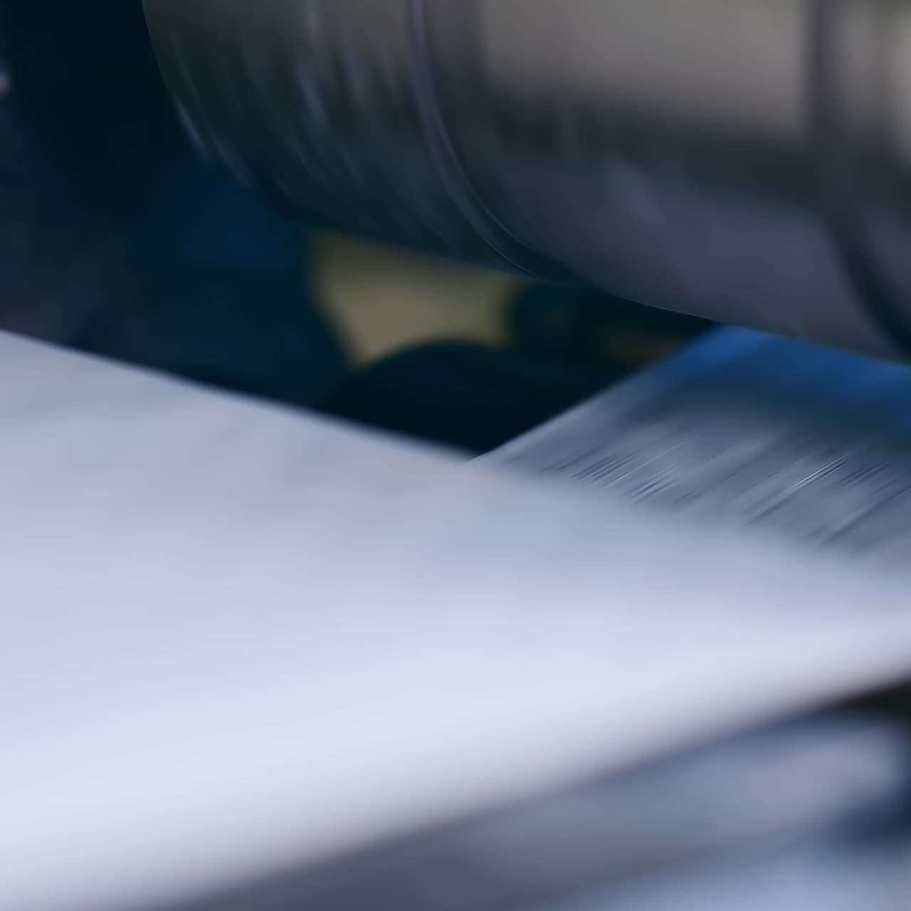 Automated production of nappies at the enterprise. Fast rotating shaft of the conveyor line with fiber for diapers. Close up