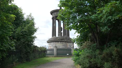 Reveal-behind-trees-of-Dugald-steward-monument-in-Edinburgh-Scotland