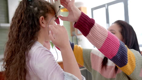 Glückliche-Biracial-Mutter-Und-Tochter-Spielen-Mit-Papierband-Und-Lächelnd-Im-Sonnigen-Wohnzimmer