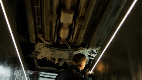 inspección del tren de aterrizaje del automóvil por parte de un mecánico