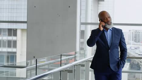 réseau d'icônes numériques contre un homme d'affaires afro-américain en train de parler sur smartphone au bureau