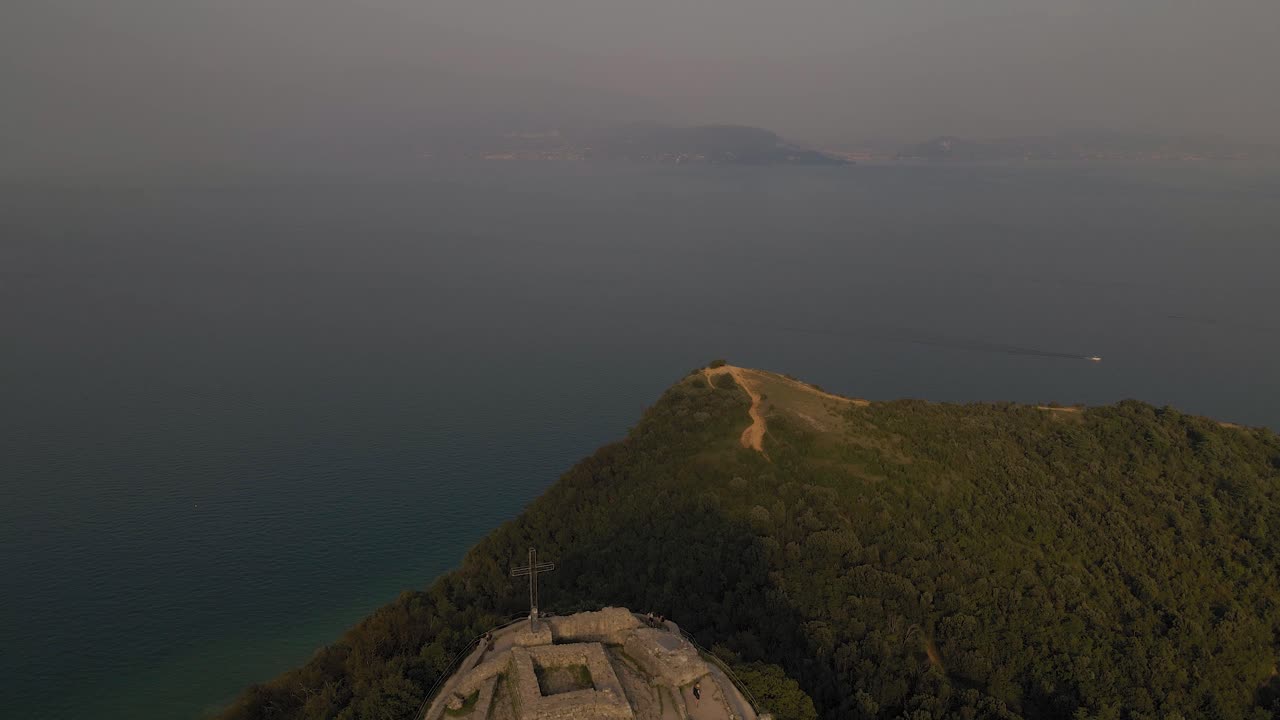 vista aérea del lago de garda desde rocca di manerba, montañas distantes emergen de la niebla