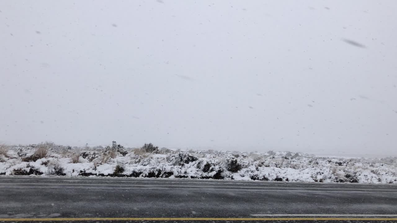 눈보라 속을 달리는 자동차 옆창 밖을 내다보면 노란색 스프레더가 지나간다