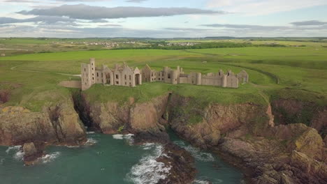 Aerial-view-of-a-Slains-Castle-ruin-at-sunrise,-Aberdeenshire,-Scotland