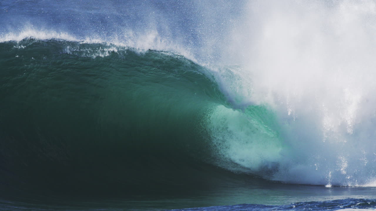 Curling wave spins forward with glowing edge and trailing mist in high speed motion