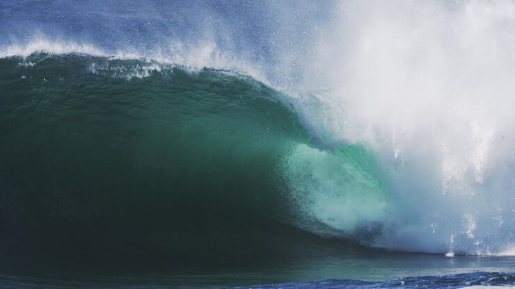 Curling wave spins forward with glowing edge and trailing mist in high speed motion