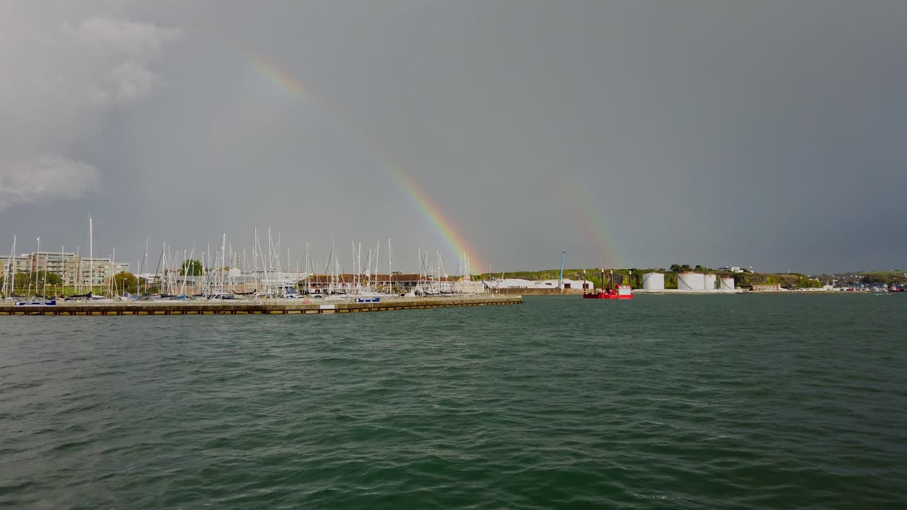 después de una fuerte tormenta de lluvia en la ciudad del sur de inglaterra de plymouth un arco iris fue visto mientras miraba a través del cuerpo de agua conocido como el sonido de plymouth