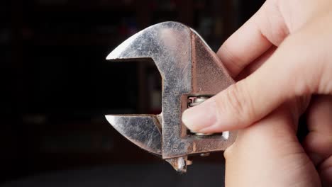 Person-tightening-wrench-on-black-background.-Close-up