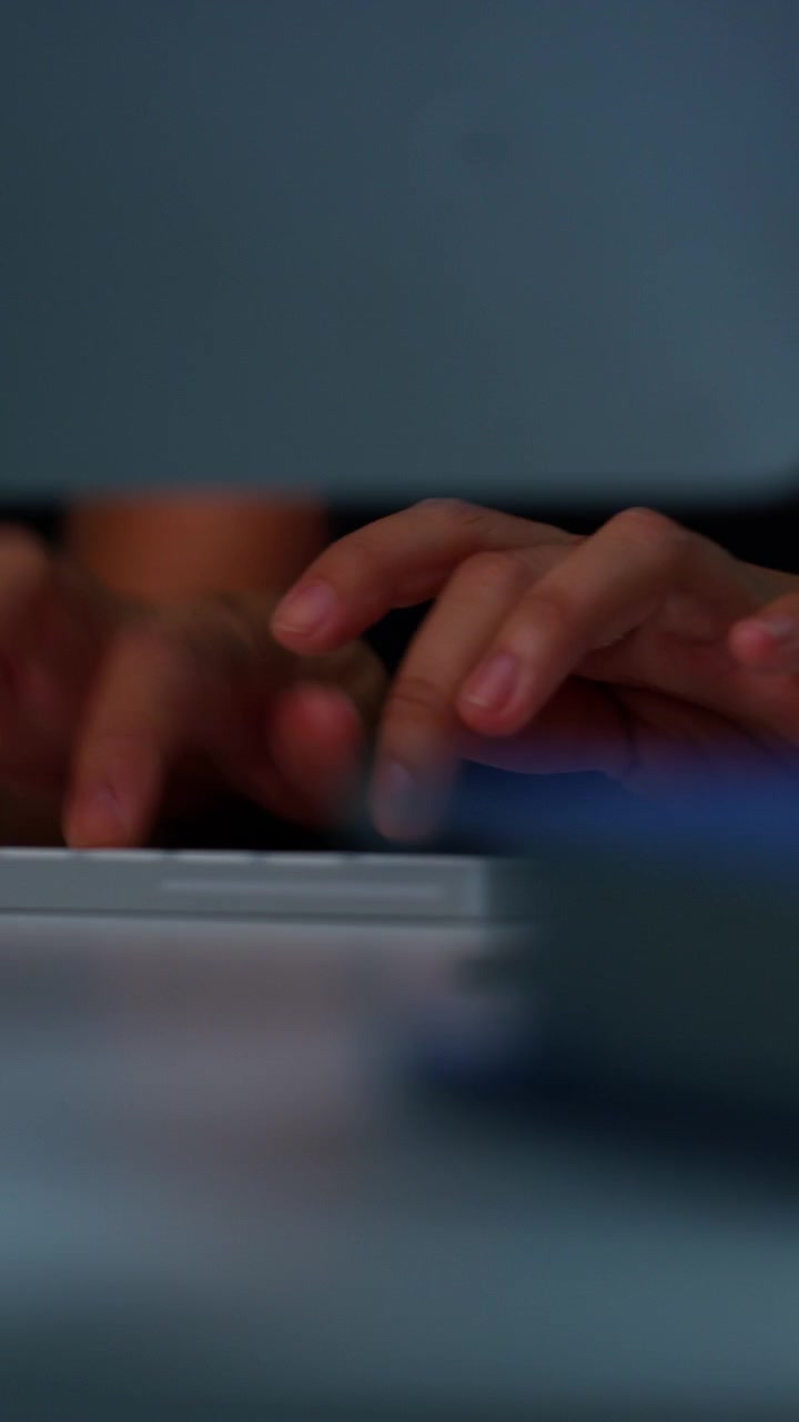 Close-up of Person Typing on Computer Keyboard in Office