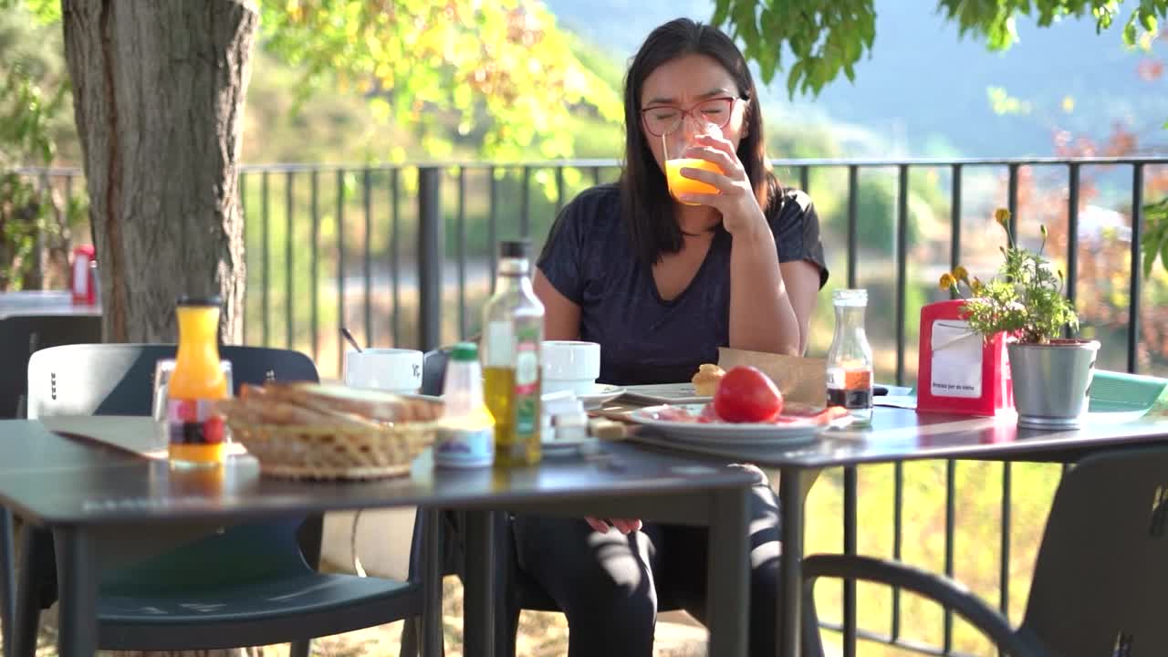 시골 의 자연 가운데 의 테이블 에 앉아 아침 식사 를 하는 여자
