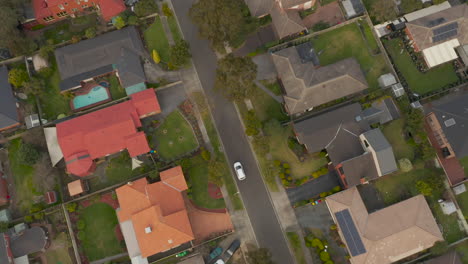 white vehicle driving through suburban neighborhood streets