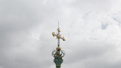 primer plano de una cruz dorada en la cima de una aguja de la iglesia