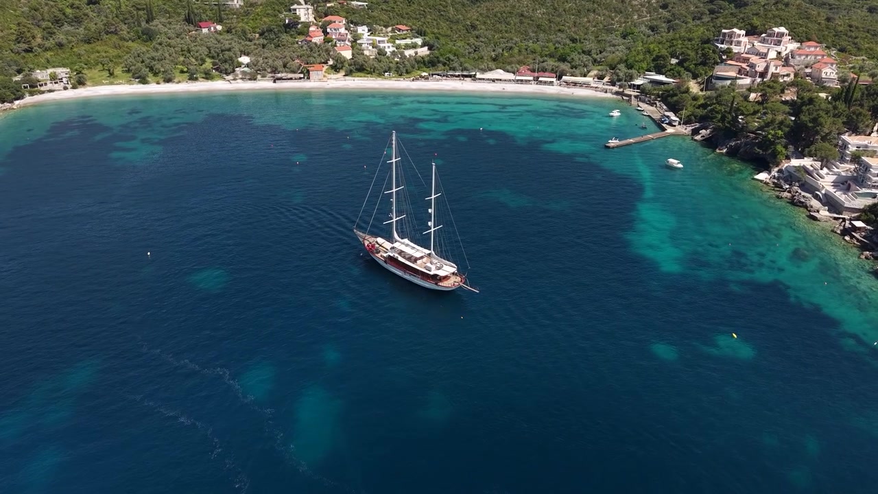 Vista aerea di una nave nelle acque blu del Mare Adriatico, vicino alla spiaggia di Zanjice in Montenegro. Ripresa con drone.