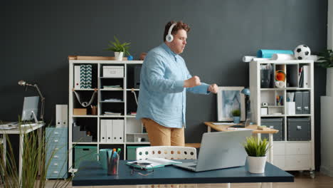 man dancing in office while listening to music