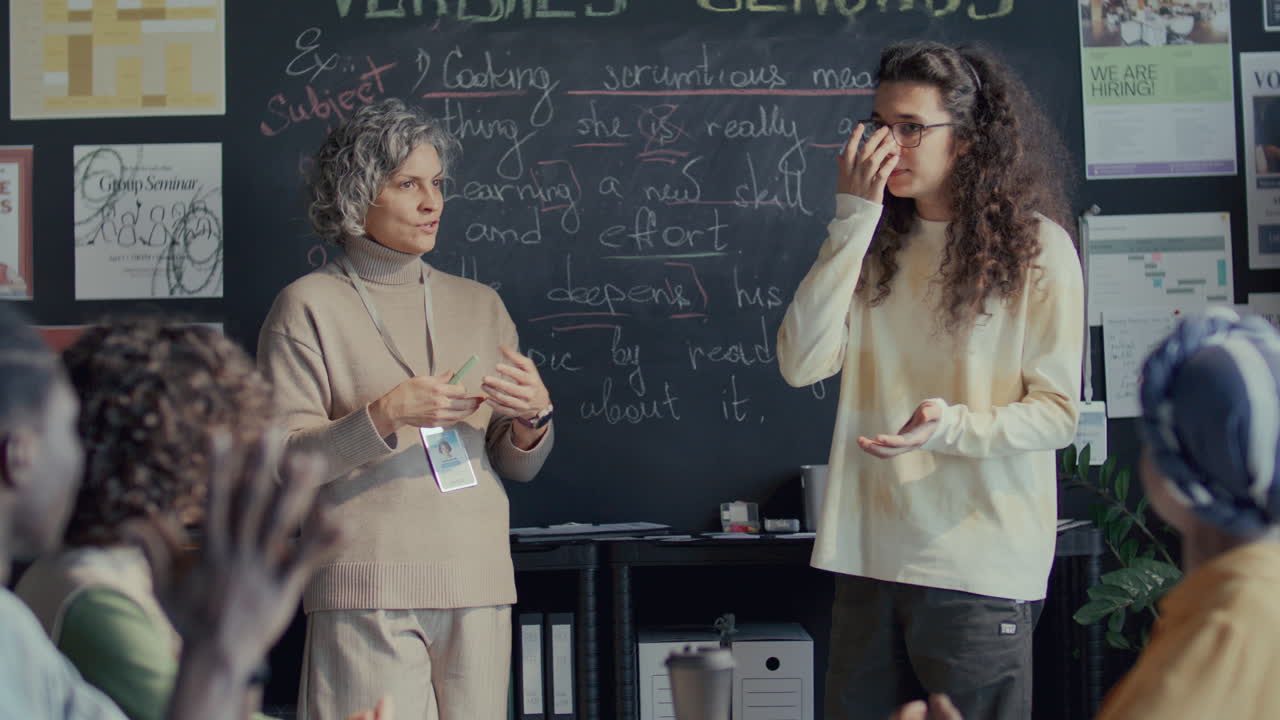 학생 이 영어 수업 중 책상 에서 교사 의 질문 에 대답 하고 있다