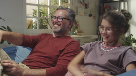 father and daughter relaxing and interacting on the couch at home