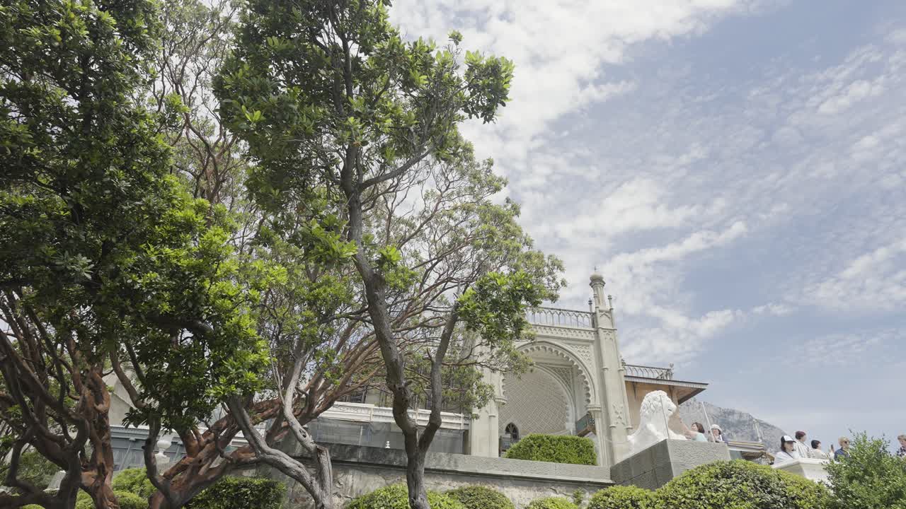exterior del palacio con árboles exuberantes y cielo nublado