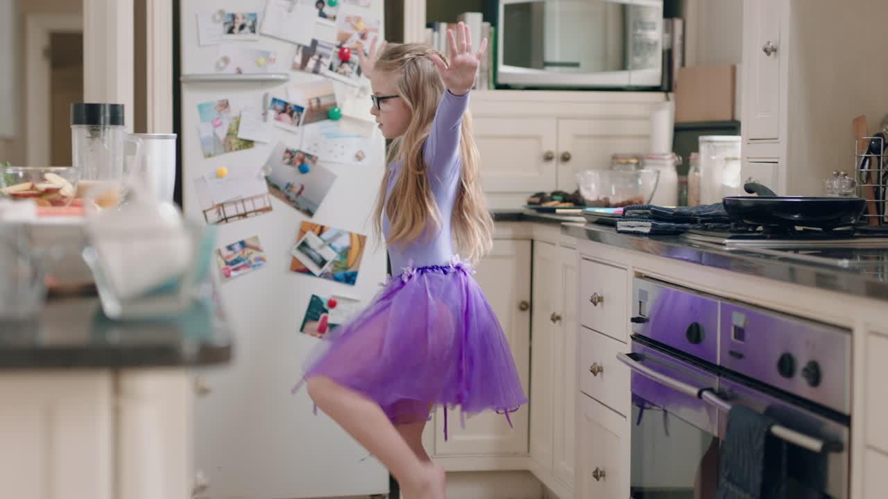 una bailarina feliz bailando en la cocina con un tutu púrpura divirtiéndose realizando movimientos de baile divertidos disfrutando de la celebración del fin de semana en casa