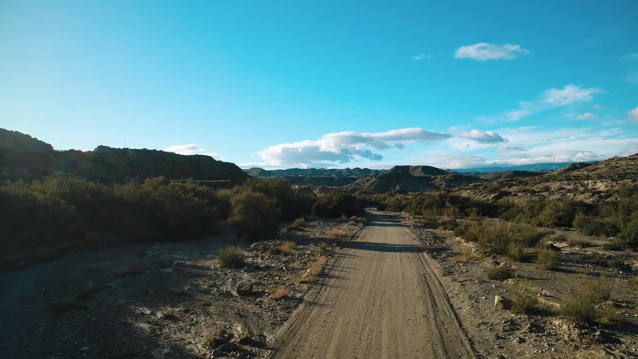 Vista de dron de un camino de tierra que atraviesa un paisaje desértico árido