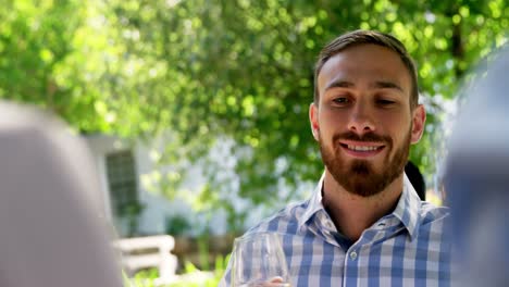 Man-interacting-with-friends-while-having-wine