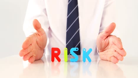 businessman showing the word risk with alphabet