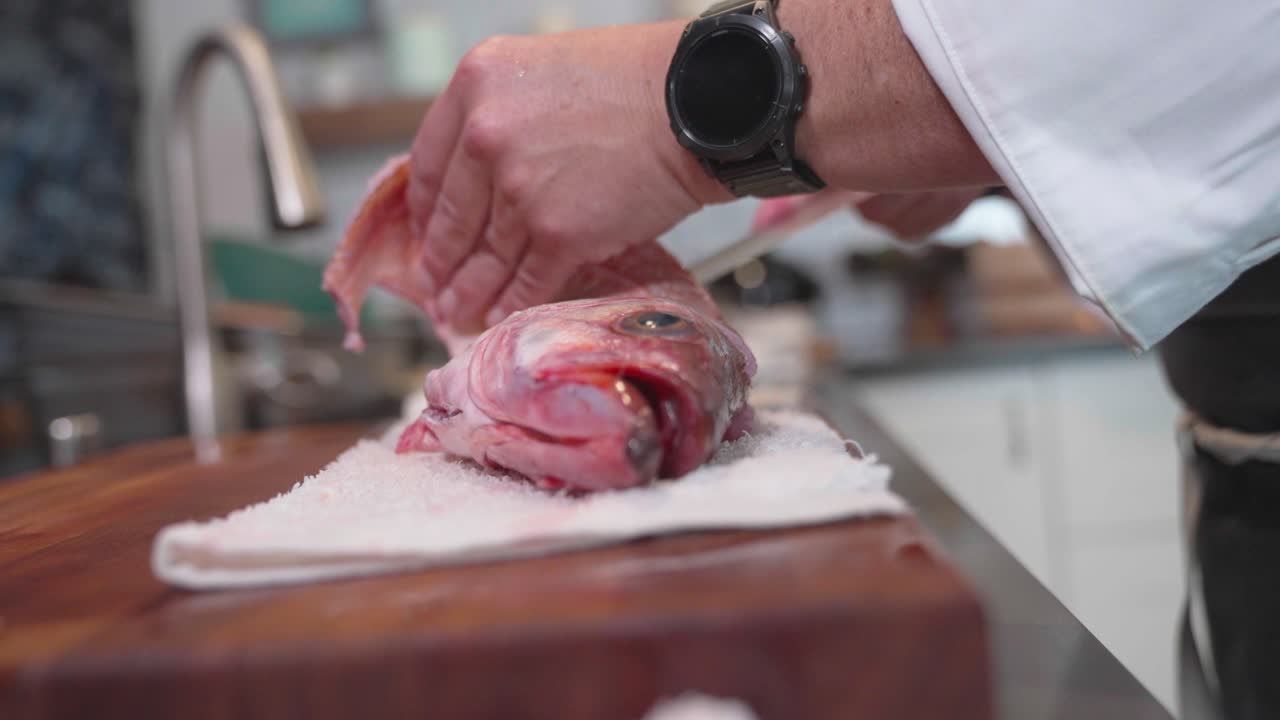 A static head-on shot captures a fish being prepped for cooking or sushi, filmed at 120 fps to emphasize precision and detail. Perfect for culinary, seafood, and food preparation content.
