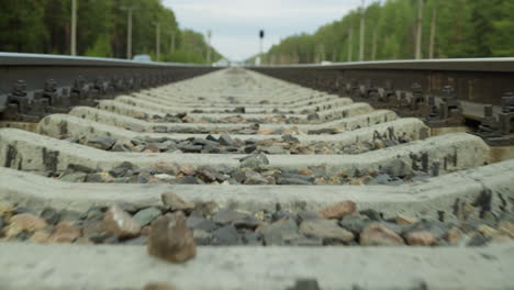 close-up fast view of a railway track focusing on the concrete sleepers and gravel ballast, with perspective leading towards the horizon