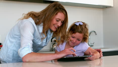 Madre-Usando-Tableta-Con-Su-Hija-En-La-Cocina