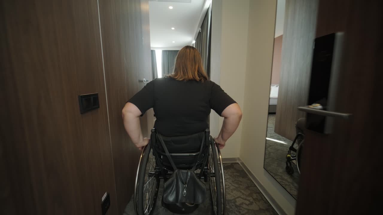 una mujer en silla de ruedas navega a través de una habitación de hotel, destacando alojamientos accesibles y diseño inclusivo. la imagen hace hincapié en la movilidad, la independencia y la infraestructura de hospitalidad moderna.