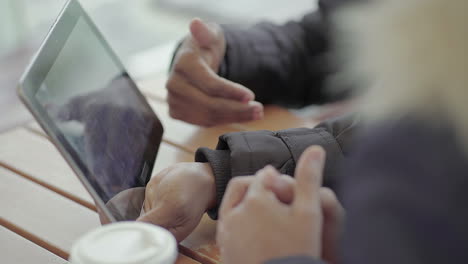 fotografía de cerca de hombres afroamericanos de mediana edad y mujeres jóvenes manos buscando datos en la tableta
