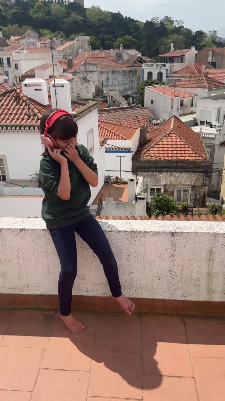Girl with Headphones on Rooftop of European City