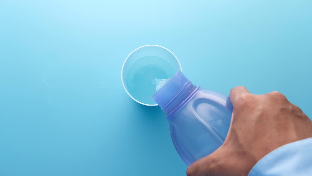 vertiendo agua de una botella en una taza