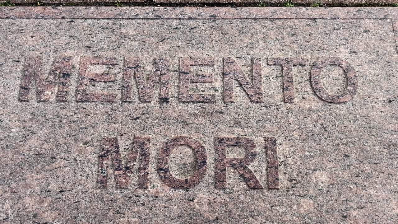 Close-up of engraved Memento Mori text on weathered stone slab with a black bug crawling on the surface. Suitable for symbolic, philosophical Stoic quotes and self-improvement content.