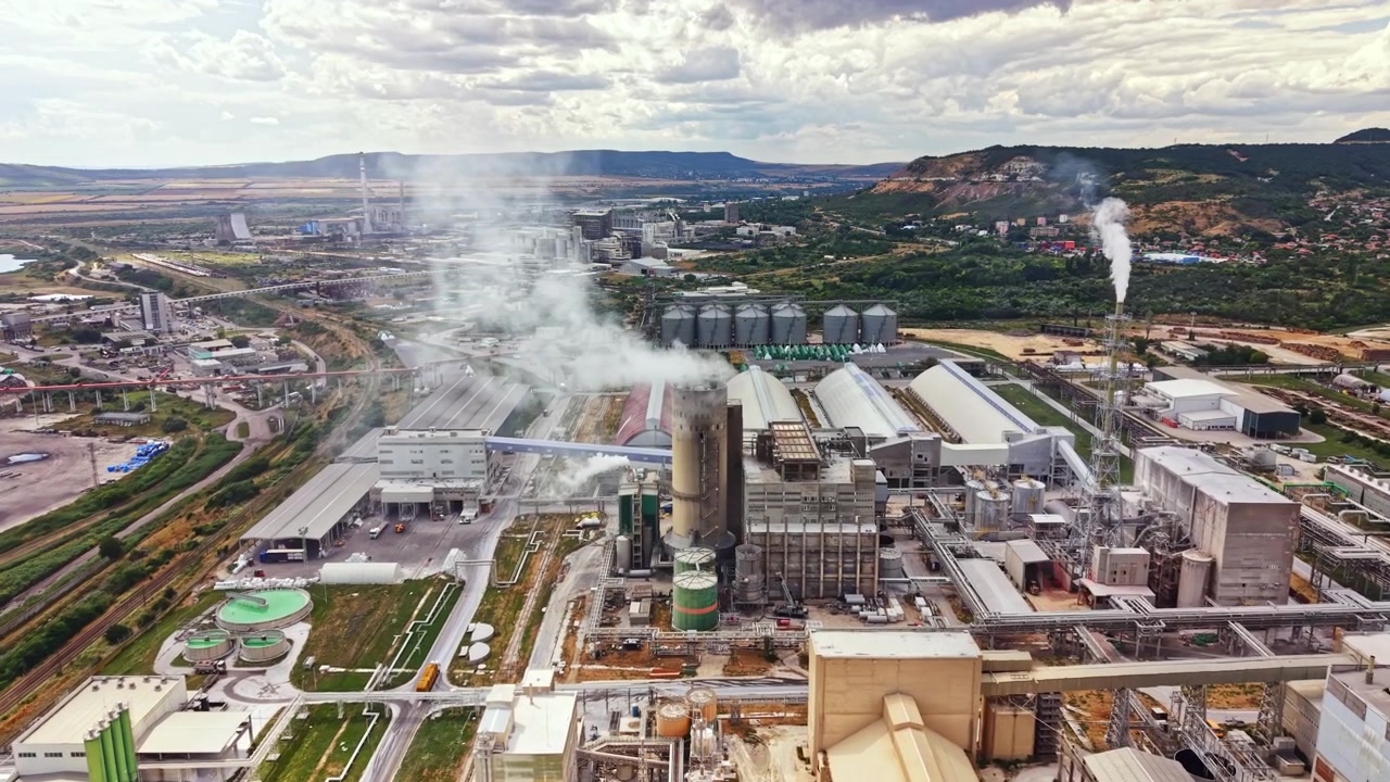 Industrianlegg med maskineri og bygninger i et avsidesliggende område under en skyet himmel