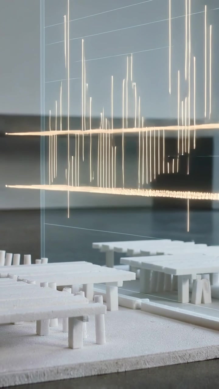 Vertical video: Rising panel and white model showing gold light planes and bars on desk for review