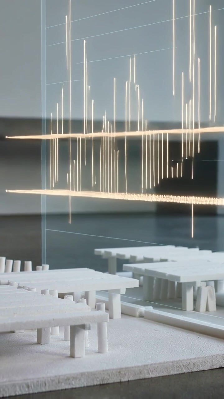 Vertical video: Rising panel and white model showing gold light planes and bars on desk for review