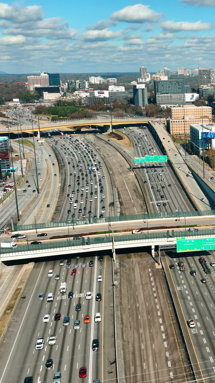 Car heavy traffic on interstate highway in center of city Atlanta. Transportation and commuter driving on road. Top down aerial view. Vertical video
