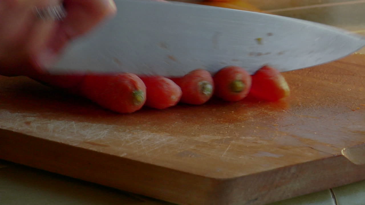 un chef corta zanahorias con un cuchillo