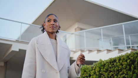 confident woman walking street suburbs. gorgeous african american realtor hold