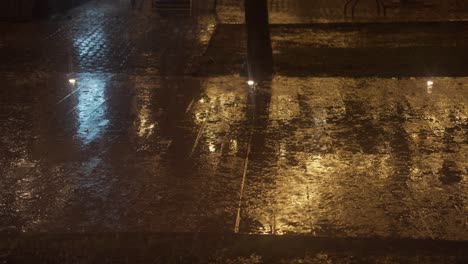 rain pouring on a wet street at night, reflecting warm and cool city lights