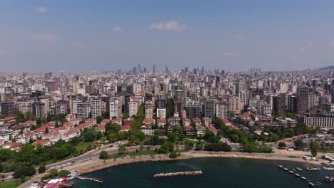 forward drone shot above kadikoy district of istanbul, high rise apartment buildings, beach