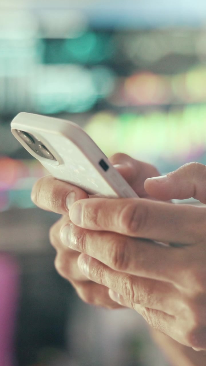 Persona che usa lo smartphone con dati finanziari sfocati sullo sfondo