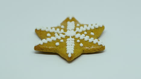 Zoomed-in-a-gingerbread-pastry-with-white-decorations-on-top-in-the-shape-of-a-Christmas-star-on-a-white-background