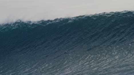 textured water from heavy wave rising to barrel and lip throwing down as mist rises off top of wave in slow motion