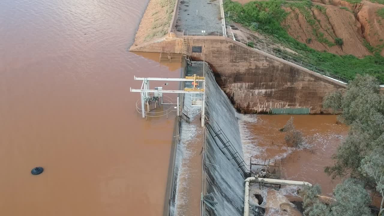 aguas de inundación cayendo en cascada sobre un muro de presa desde un dron 11