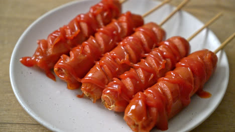 fried sausage skewer with ketchup on white plate