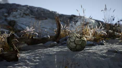 an old torn soccer ball thrown lies on sand of sea beach