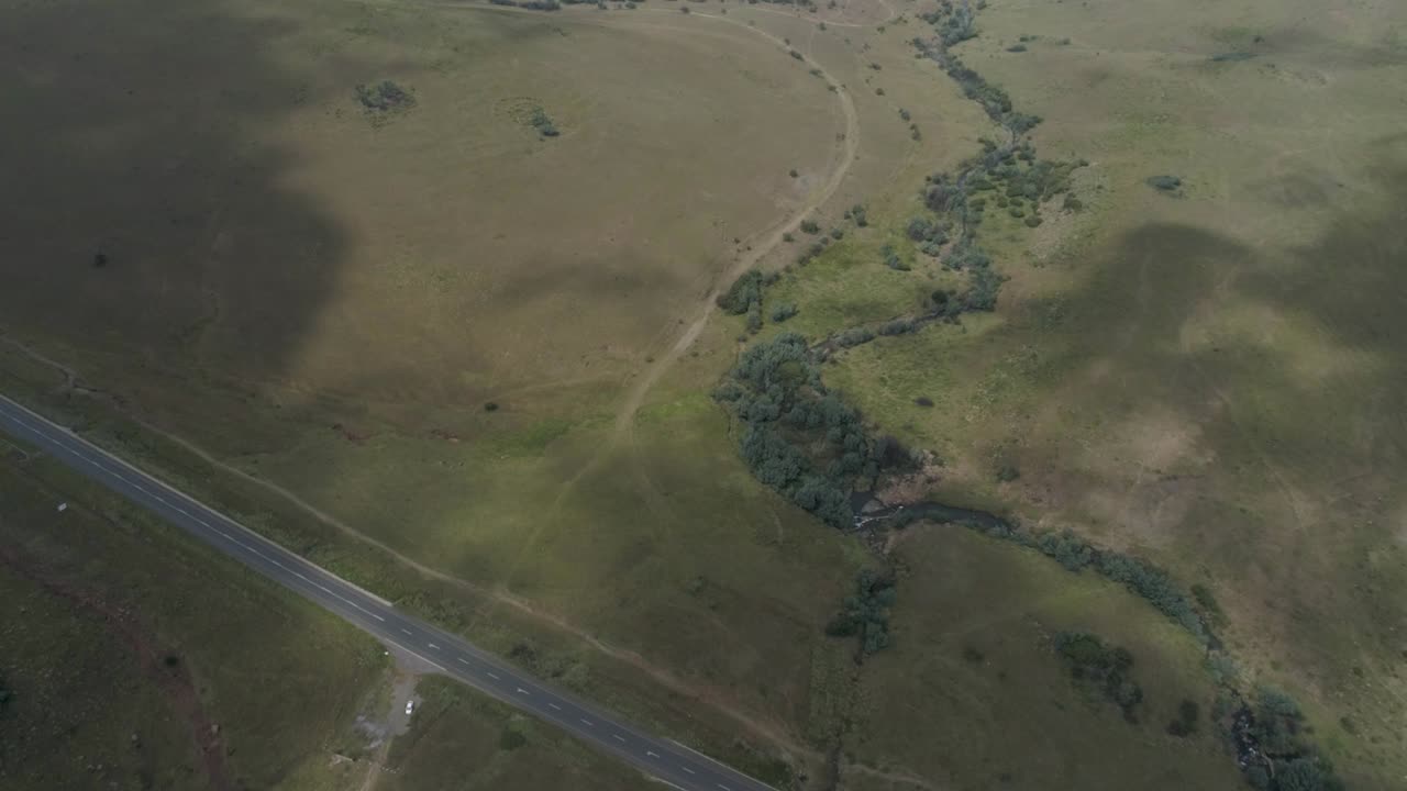 높은 드론 비행 에서 볼 수 있는 초록색 언덕 으로 둘러싸인 계곡 의 도로